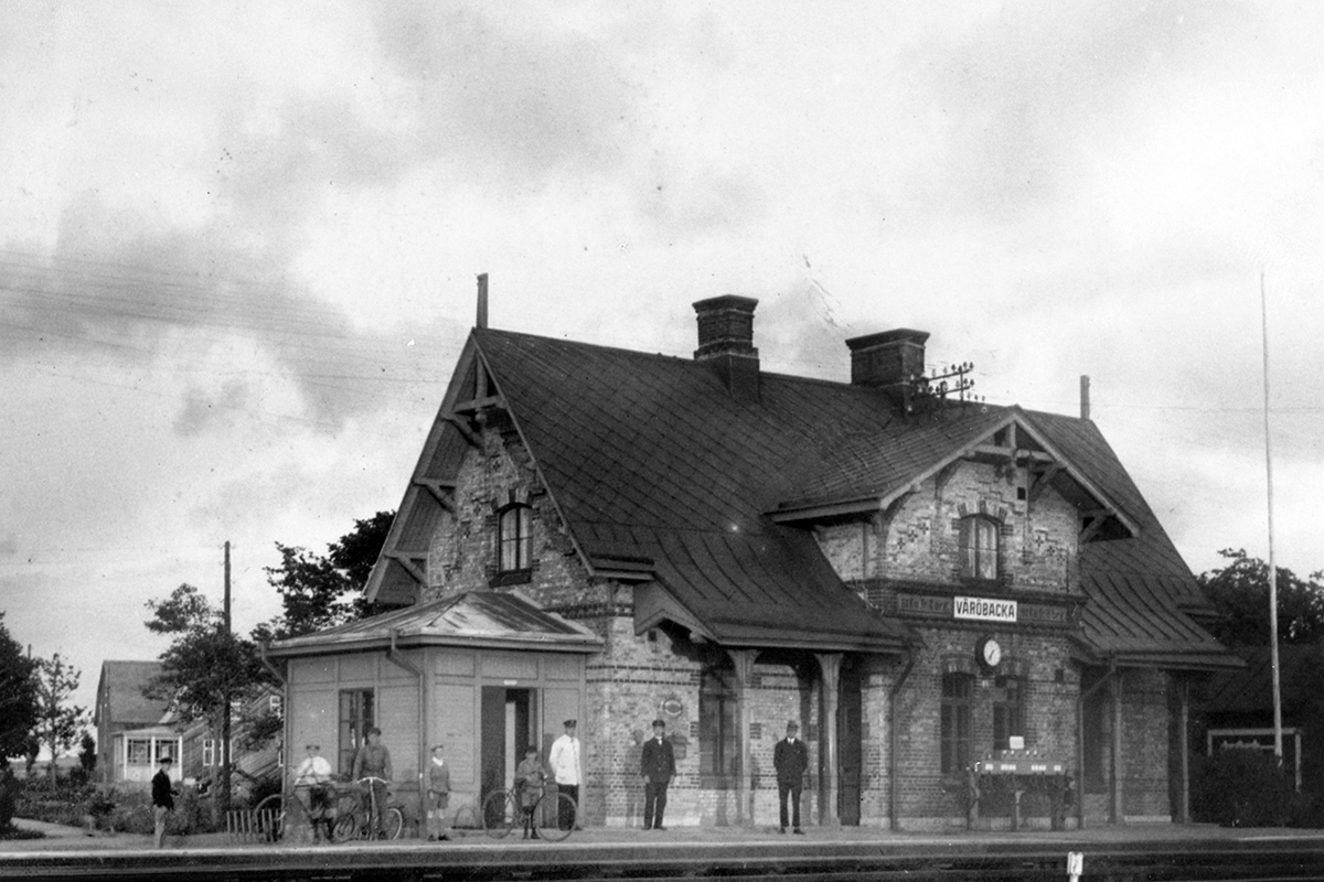 Väröbacka stationshus. Framför tegelbyggnaden står människor och väntar. Kanske är bilden tagen på 30-talet.